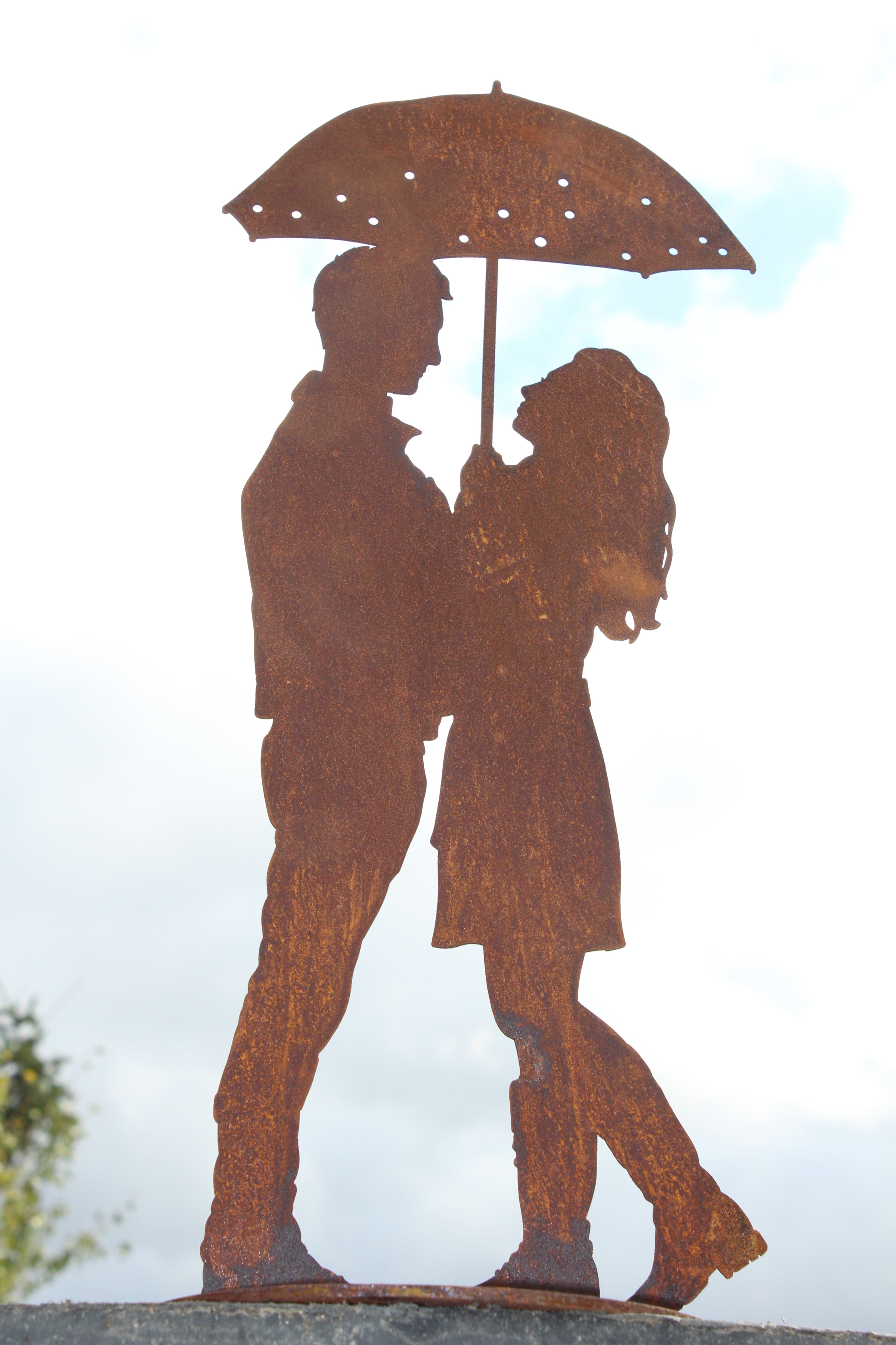 kleines Paar unter dem Regenschirm auf Platte
