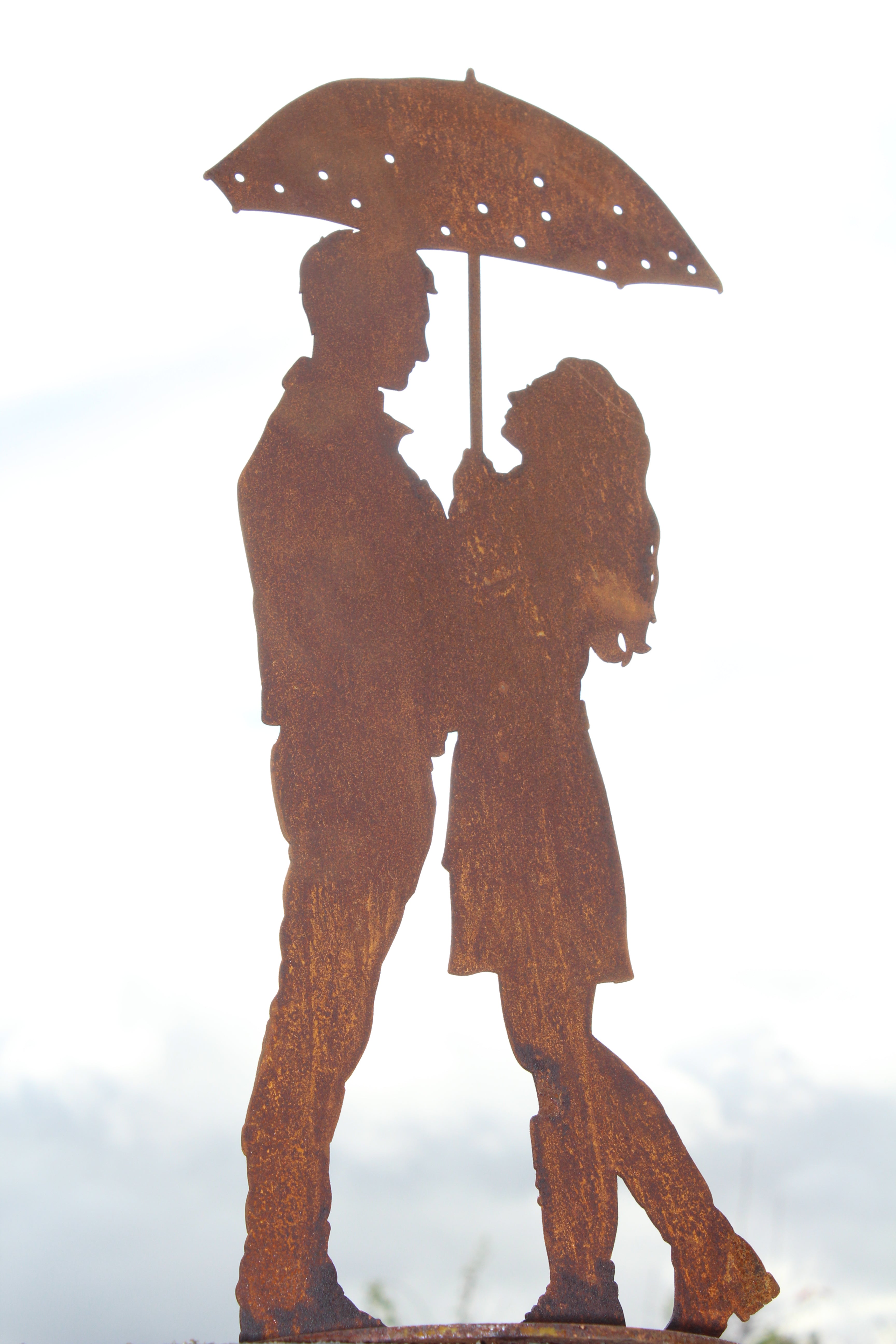 kleines Paar unter dem Regenschirm auf Platte